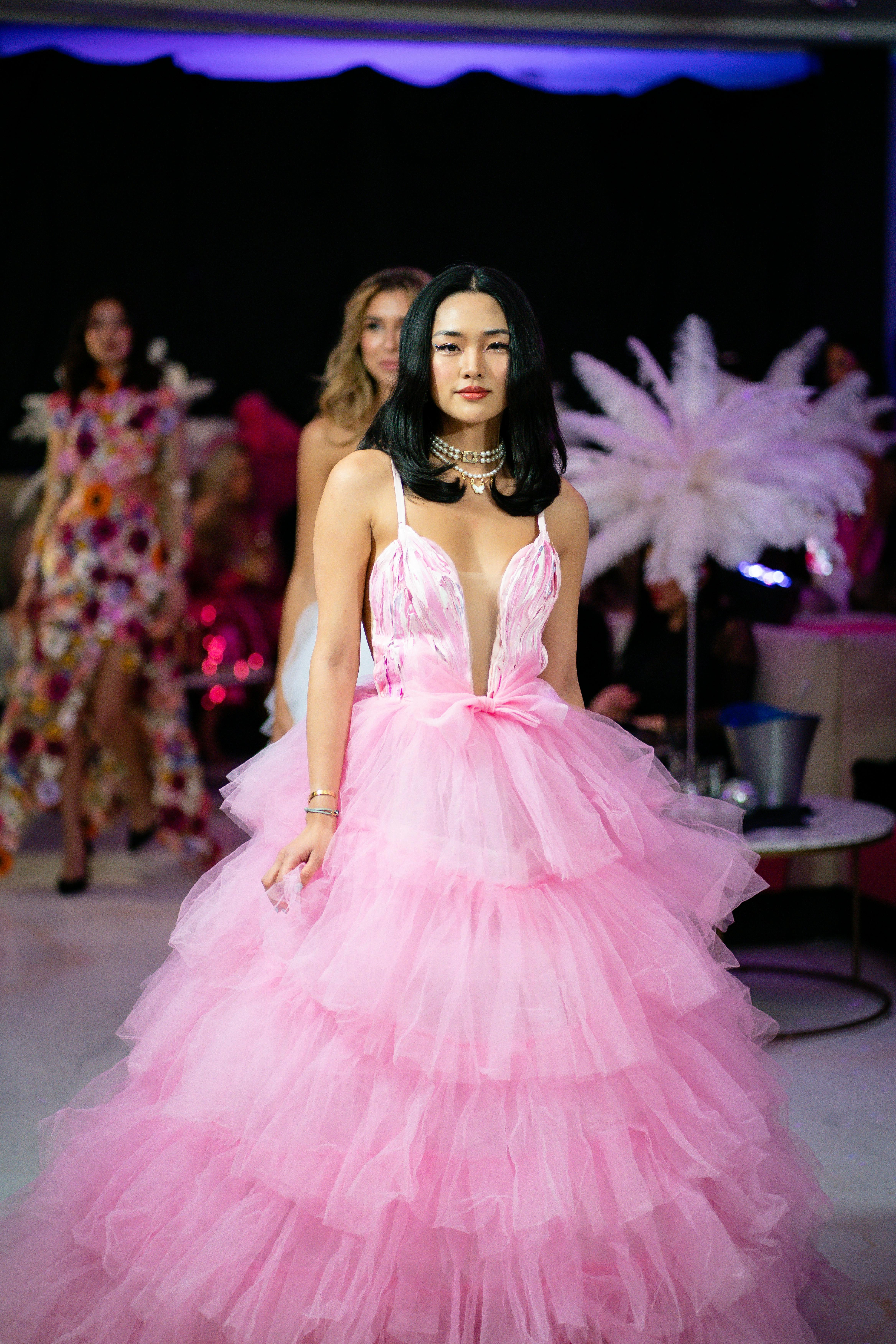 Latin fashion runway model wearing pink couture dress during fashion show